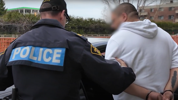 A suspect is shown being taken into custody in Quebec in connection with a fraud investigation. (handout)