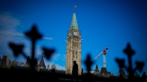 A person makes their way past the Peace Tower on Parliament Hill in Ottawa on Tuesday, Feb. 13, 2024. THE CANADIAN PRESS/Sean Kilpatrick