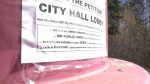 A sign against St. Albert's plans for Millennium Park can be seen on a trash can in the park's area in April, 2024. (Evan Kenny/CTV News Edmonton) 