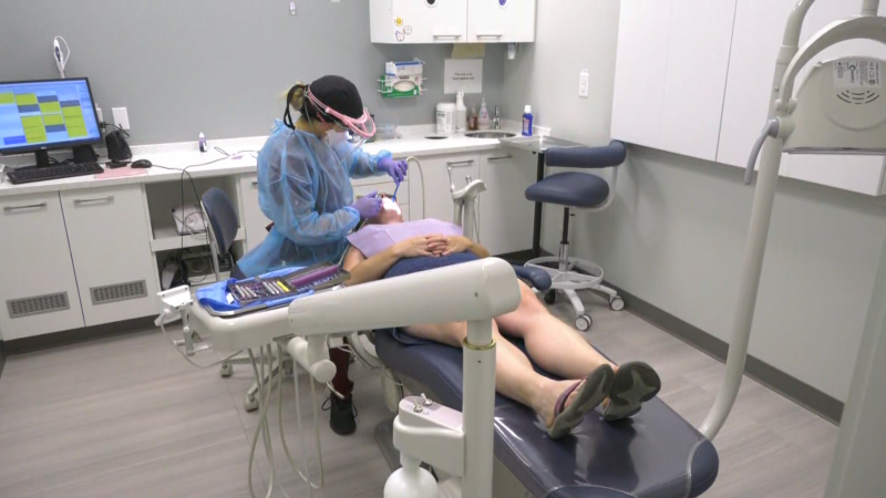 A dental hygienist performs a cleaning.