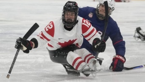 Greg Westlake, left, of Canada and Brody Roybal of the United States battle for the puck during their para ice hockey finals match at the 2022 Winter Paralympics in Beijing on March 13, 2022. THE CANADIAN PRESS/AP-Dita Alangkara