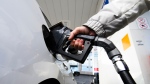 A woman gasses up at a gas station in Mississauga, Ont., Tuesday, February 13, 2024. Ontario Premier Doug Ford says his government will introduce legislation that would put any future provincial carbon pricing program to a referendum. THE CANADIAN PRESS/Christopher Katsarov