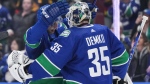 Vancouver Canucks' Ilya Mikheyev, left, and goalie Thatcher Demko celebrate after Vancouver defeated the Calgary Flames 4-1 during an NHL hockey game in Vancouver, on Tuesday, April 16, 2024. THE CANADIAN PRESS/Darryl Dyck