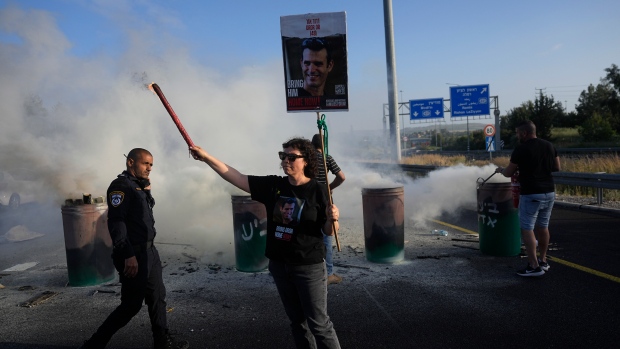 Relatives of hostages held in the Gaza Strip block Highway 1, the main route linking Tel Aviv and Jerusalem, to call for a deal to release all hostages, Friday, April 19, 2024. (AP Photo/Ohad Zwigenberg)