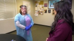 Mandy Lamoureux (left), a former educational assistant, demonstrates the PPE needed for her to work safely with an aggressive student with complex needs. (Nicole Lampa/CTV News Edmonton)