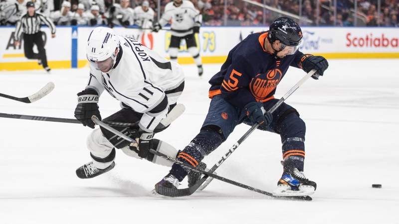 Los Angeles Kings' Anze Kopitar (11) and Edmonton Oilers' Cody Ceci (5) battle for the puck during third period NHL action in Edmonton on March 28, 2024.(Jason Franson)