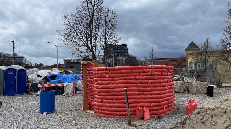 A sandbag structure under construction at an encampment in Kitchener on April 20, 2024. (Hannah Schmidt/CTV News)