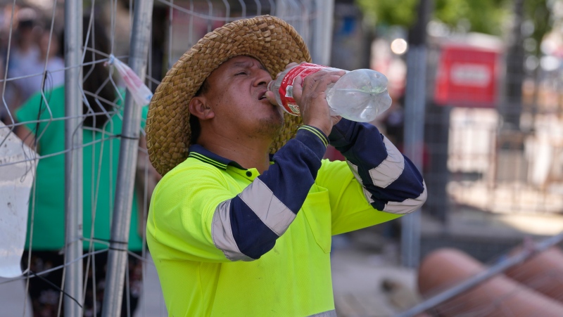 A road worker stops to take a drink of water in Madrid, Spain, Monday, July 18, 2022. (AP Photo/Paul White, File)