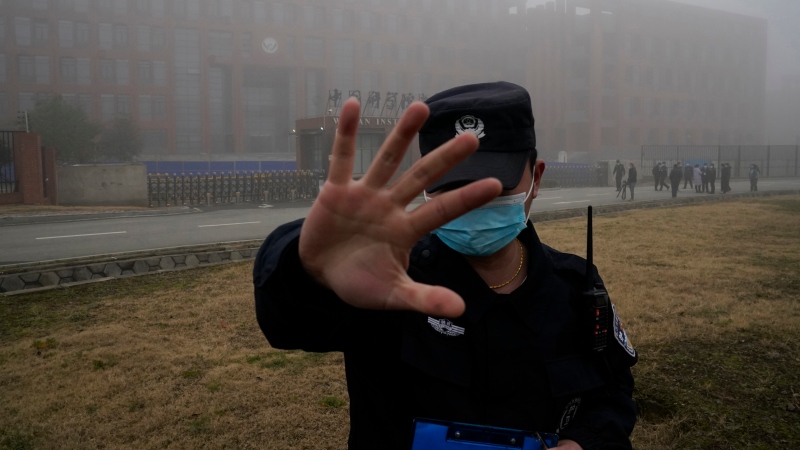 A security person moves journalists away from the Wuhan Institute of Virology after a World Health Organization team arrived for a field visit in Wuhan in China's Hubei province on Feb. 3, 2021. (AP Photo/Ng Han Guan, File)