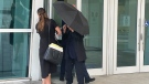 Celebrity handbag designer Nancy Gonzalez hides under an umbrella as she walks with her lawyer Andrea Lopez outside the federal courthouse Monday, April 22, 2024, in Miami. (Josh Goodman / AP Photo)