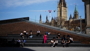People take advantage of the warm weather at the Bank of Canada near Parliament Hill in Ottawa on Tuesday, April 9, 2024. THE CANADIAN PRESS/Sean Kilpatrick