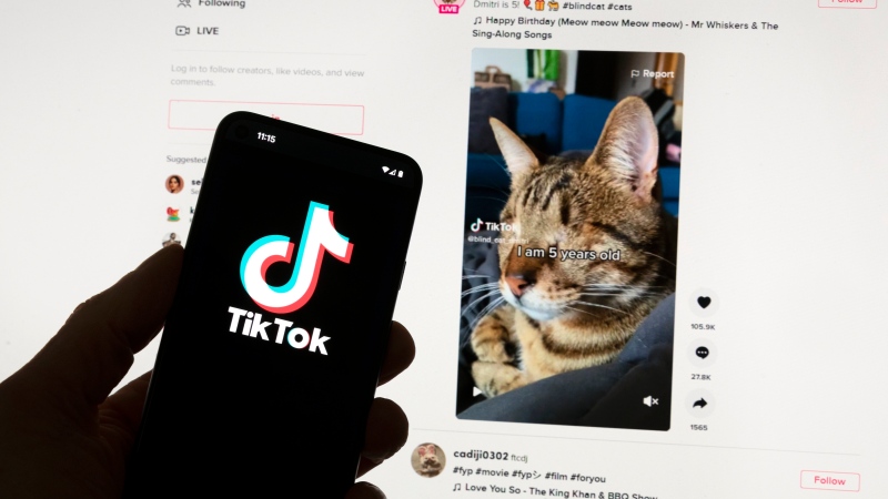 The TikTok logo is seen on a mobile phone in front of a computer screen which displays the TikTok home screen, in Boston, Saturday, March 18, 2023 (AP Photo/Michael Dwyer, File)