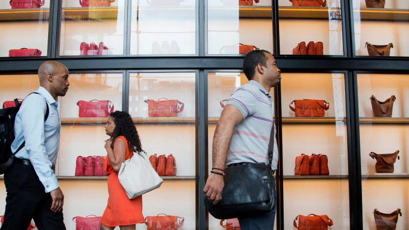 People pass displays of Coach handbags as they walk through the lobby of 10 Hudson Yards, Tuesday, May 31, 2016, in New York. (Mark Lennihan / AP Photo)