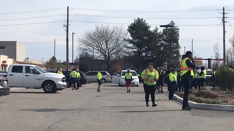 Employees evacuated from the Canada Post distribution centre on Woodlawn Road in Guelph gather in a nearby parking lot. (Chris Thomson/CTV Kitchener)