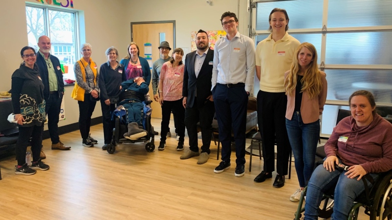 L’arche community members, alongside London Transit employees and Huron University College students, are seen at an event to discuss paratransit services in London, Ont. on April 23, 2024. (Reta Ismail/CTV News London) 