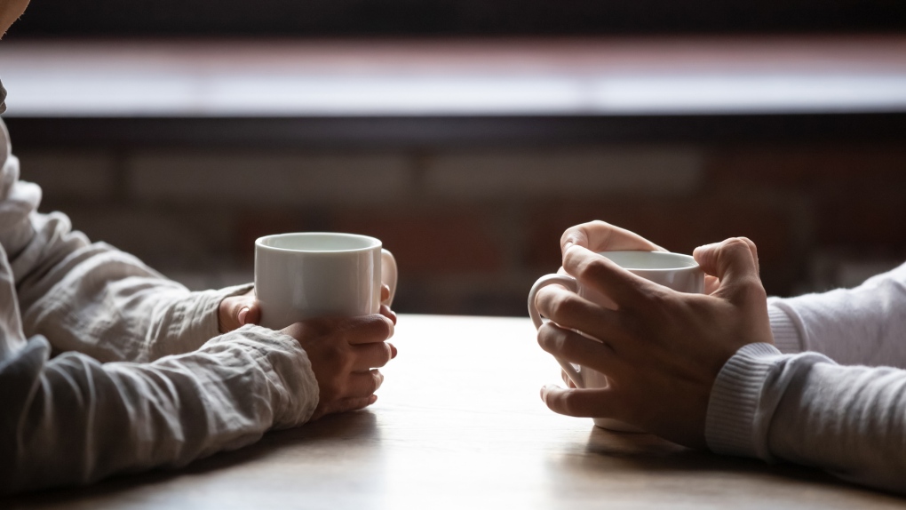Two people talking over coffee