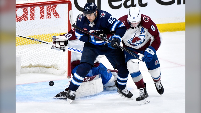 Colorado Avalanche's Cale Makar (8) and Winnipeg Jets' Nino Niederreiter (62) fight for possession of the rebound during the third period in Game 2 of their NHL hockey Stanley Cup first-round playoff series in Winnipeg, Tuesday April 23, 2024. THE CANADIAN PRESS/Fred Greenslade