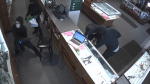 Suspects smash glass display cases during a jewellery store robbery in Toronto, captured in a video provided by Toronto police. 