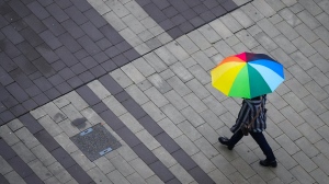 A pedestrian carries an umbrella as light rain falls in Surrey, B.C., on Friday, October 21, 2022. THE CANADIAN PRESS/Darryl Dyck