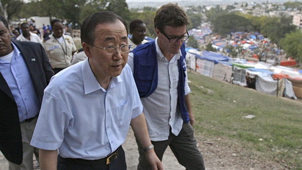 U.N. Secretary-General Ban Ki-moon, left, returns to his motorcade after visiting a makeshift camp for earthquake survivors, background, set up at the Petionville Golf Club in Port-au-Prince, Sunday, March 14, 2010. (AP / Andres Leighton)