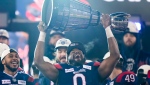 Then-Montreal Alouettes defensive end Shawn Lemon hoists the Grey Cup on Nov. 19, 2023. (Frank Gunn / The Canadian Press)