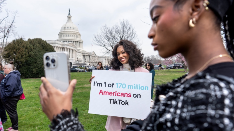 Devotees of TikTok, Mona Swain, centre, and her sister, Rachel Swain, right, both of Atlanta, monitor voting at the Capitol in Washington, as the House passed a bill that would lead to a nationwide ban of the popular video app if its China-based owner doesn't sell, March 13, 2024. (AP Photo/J. Scott Applewhite) 