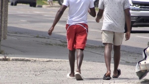Two men who identified themselves as asylum seekers walk along York Street in London, Ont. in August 2023. (Daryl Newcombe/CTV News London)