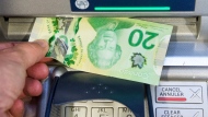 Money is removed from an ATM in Montreal, Monday, May 30, 2016. (Ryan Remiorz / The Canadian Press)