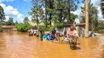 A family uses a boat after fleeing floodwaters that wreaked havoc in the Githurai area of Nairobi, Kenya, Wednesday, Apr. 24, 2024. Heavy rains pounding different parts of Kenya have led to the deaths of at least 35 people since mid-March and displaced more than 40,000 people, according to the U.N., which cites Red Cross figures in the most recent update. (AP Photo/Patrick Ngugi)
