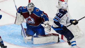 Colorado Avalanche goaltender Alexandar Georgiev, left, deflects a shot by Winnipeg Jets left wing Nikolaj Ehlers (27) in the third period of Game 4 of an NHL Stanley Cup first-round playoff series Sunday, April 28, 2024, in Denver. (David Zalubowski/AP Photo)