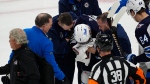 Trainers attend to Winnipeg Jets center Vladislav Namestnikov after he was hit in the face by a slap shot in the third period of Game 4 of an NHL Stanley Cup first-round playoff series against the Colorado Avalanche, Sunday, April 28, 2024, in Denver. (AP Photo/David Zalubowski)