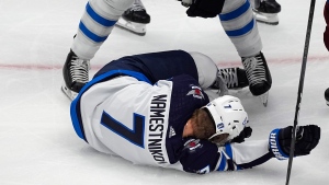 Winnipeg Jets center Vladislav Namestnikov (7) falls to the ice after taking a slap shot to the face in the third period of Game 4 of an NHL Stanley Cup first-round playoff series against the Colorado Avalanche, Sunday, April 28, 2024, in Denver. (AP Photo/David Zalubowski)