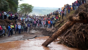People gather on a bridge where a woman's body was retrieved, after floodwater washed away houses, in Kamuchiri Village Mai Mahiu, Nakuru County, Kenya, Tuesday, April 30, 2024. (AP Photo/Brian Inganga)