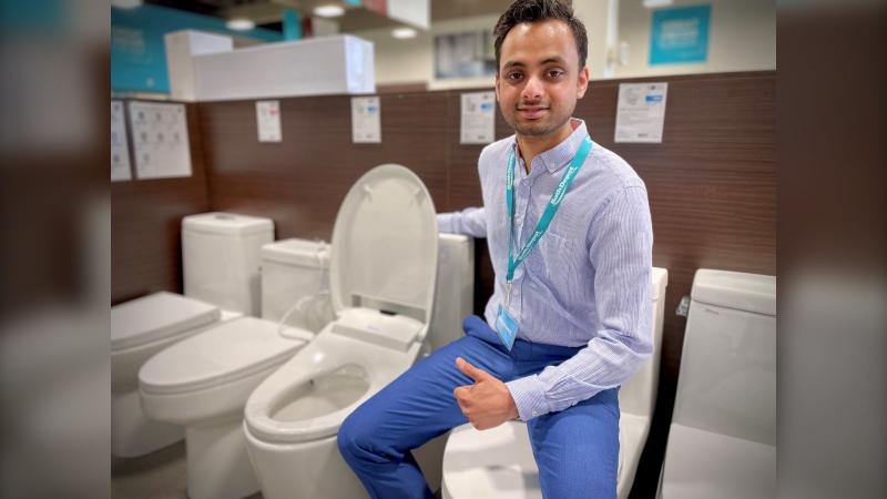 Bath Depot store manager Himalaya Srivastava poses with a smart toilet. (Spencer Turcotte/CTV Kitchener)