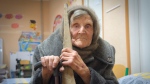 In this photo provided by the Ukrainian National Police of Donetsk region, 98-year-old Lidia Lomikovska sits in a shelter after she escaped Russian-occupied territory in the Donetsk region, Ukraine, April 26, 2024.  (Ukrainian National Police of Donetsk region via AP)