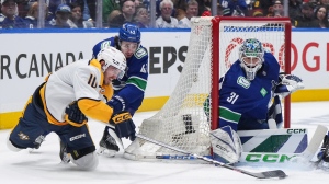 Nashville Predators' Colton Sissons (10) attempts a wrap-around on Vancouver Canucks goalie Arturs Silovs (31) while being checked by Quinn Hughes (43) during the second period in Game 5 of an NHL hockey Stanley Cup first-round playoff series, in Vancouver, on Tuesday, April 30, 2024. THE CANADIAN PRESS/Darryl Dyck