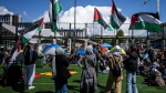 People wave flags during a student encampment for Palestine at the University of British Columbia campus in Vancouver, Monday, April. 29, 2024. THE CANADIAN PRESS/Ethan Cairns