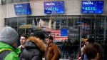 Pedestrians walk past the NASDAQ building as the stock price of Trump Media & Technology Group Corp. is displayed on screens, March 26, 2024, in New York. (AP / Frank Franklin II)