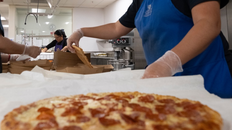 Cafeteria workers prepare pizza for student lunches (Richard Vogel/The Associated Press)