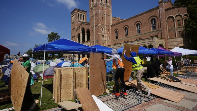 Demonstrators restore a protective barrier at an encampment on the UCLA campus, the morning after clashes between pro-Israel and pro-Palestinian groups, May 1, 2024, in Los Angeles. (AP Photo/Jae C. Hong)
