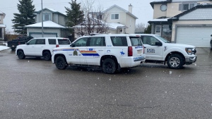 Mounties out of Okotoks, Alta., investigate a shooting in the town south of Calgary on May 1, 2024. A 26-year-old Okotoks man was charged in the shooting Friday.