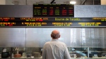 A man watches the financial numbers on the digital ticker tape at the TMX Group in Toronto's financial district, Friday, May 9, 2014. THE CANADIAN PRESS/Darren Calabrese