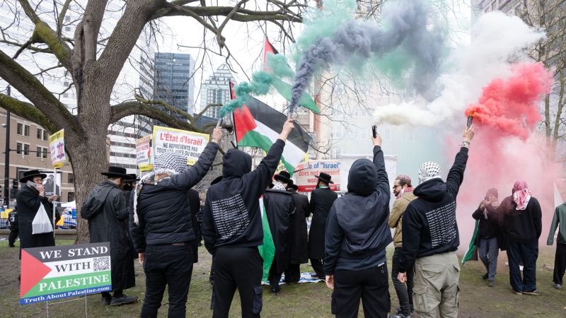 Palestinian supporters burn flares as pro-Palestinian and pro-Israel supporters hold opposing demonstrations at the McGill University campus, in Montreal, Thursday, May 2, 2024. (Ryan Remiorz, The Canadian Press)