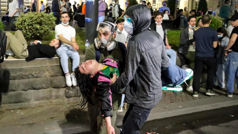 Demonstrators carry a young woman wounded in clashes with police during an opposition protest against "the Russian law" near the parliament building in Tbilisi, Georgia, May 2, 2024. (AP Photo/Zurab Tsertsvadze)