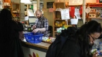 Store manager Zachary Weingarten helps members cash out at the Karma Co-op Food Store in Toronto, Friday, March 15, 2024. THE CANADIAN PRESS/Chris Young