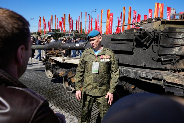 A Russian officer, speaks to foreign military attaches standing at a U.S.-made M1 Abrams tank during their visit an exhibition of Western military equipment captured from Kyiv forces during the fighting in Ukraine, in Moscow on Friday, May 3, 2024. (AP Photo/Alexander Zemlianichenko)