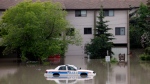A police car sits stuck in a parking lot of an apartment building after heavy rains have caused flooding, closed roads, and forced evacuation in Calgary, Alta., Friday, June 21, 2013.  (THE CANADIAN PRESS/Jeff McIntosh)