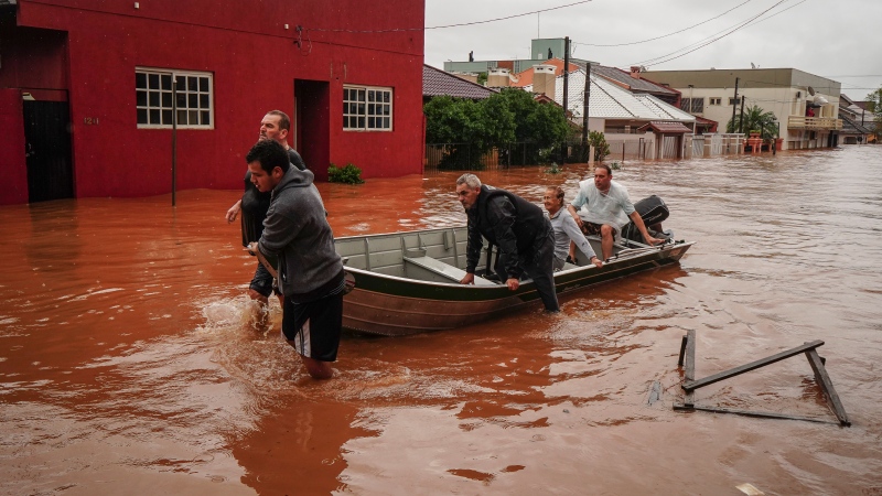 People evacuate a flooded area after heavy rain in Sao Sebastiao do Cai, Rio Grande do Sul state, Brazil, Thursday, May 2, 2024. (Carlos Macedo / AP Photo)
