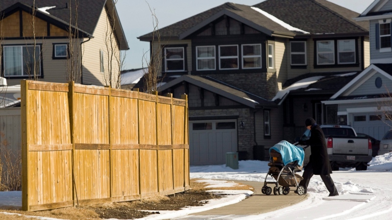 A woman pushes a baby carriage in the King's Heights neighborhood in Airdrie, Alta., Thursday, Feb. 16, 2012. the death of a newborn infant killed by a dog has shocked the quiet commuter town. (THE CANADIAN PRESS/Jeff McIntosh)