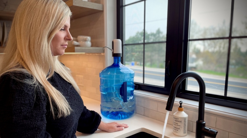 Jacqueline Fell from Puslinch, Ont. stares at the water coming from her tap on May 2, 2024 after an investigation into a foul smell in July 2023. (Spencer Turcotte/CTV News)